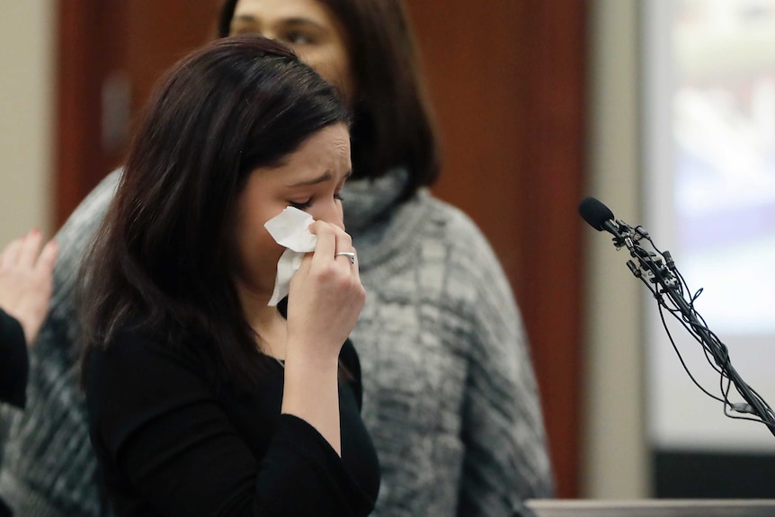 Gymnast Kaylee Lorincz wipes away tears with a tissue.