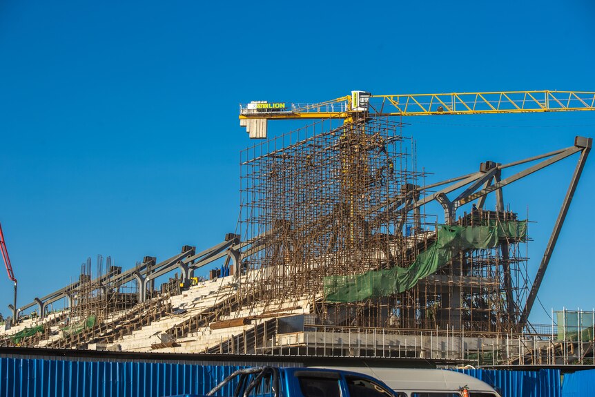 Construction work showing a stadium being built.
