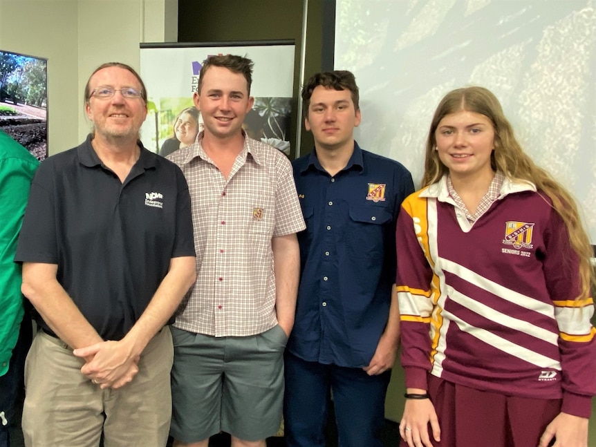 A man wearing black tee, khaki shorts, two boys in shirts, shorts and a girl with long hair in school uniform. Ausnew Home Care, NDIS registered provider, My Aged Care