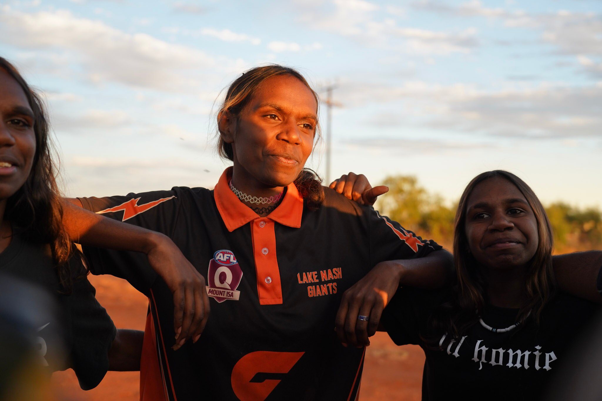 Women huddling at sunset