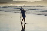 Two men hold their fishing rods at Parry Beach in WA.