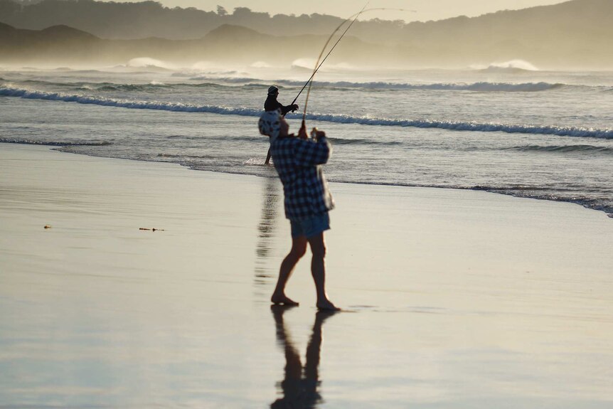 Two men hold their fishing rods at Parry Beach in WA.