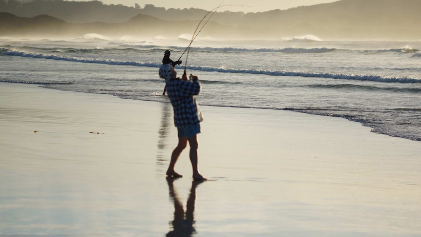 Two men hold their fishing rods at Parry Beach in WA.