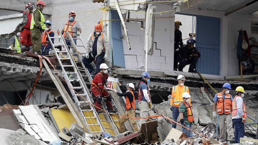 Rescue specialists work at the site of a collapsed building.