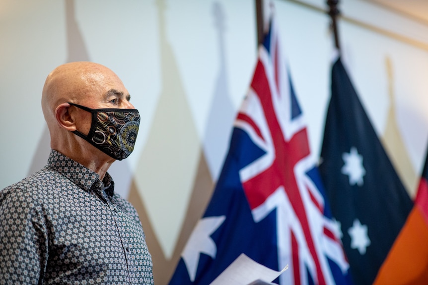 A photo of  NT Chief Health Officer Hugh Heggie. He's wearing a face mask and a collared shirt.