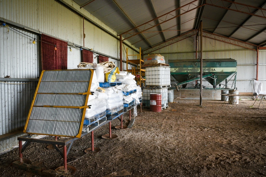 large vats of chemicals moved off the flood inside a shed