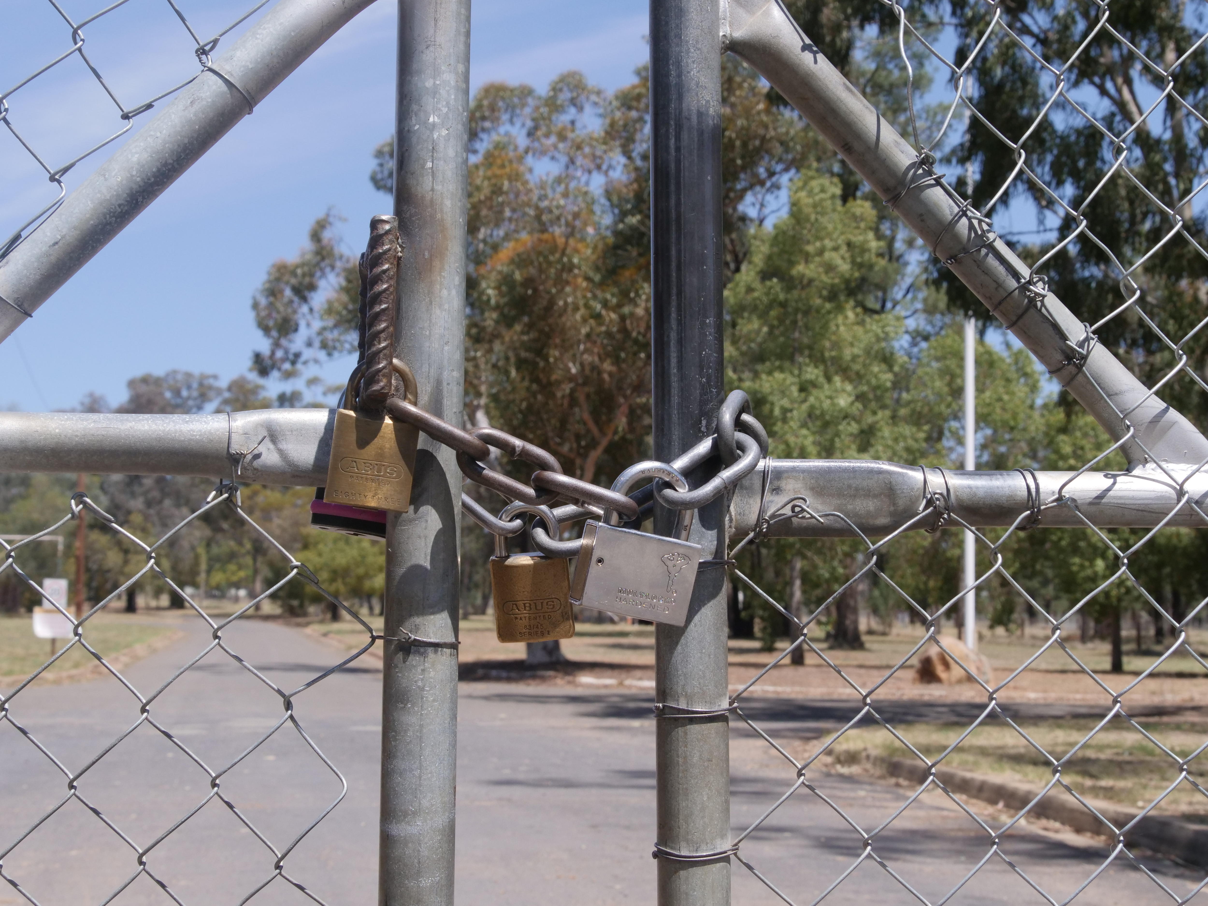 A close up photo of a padlocked gate.