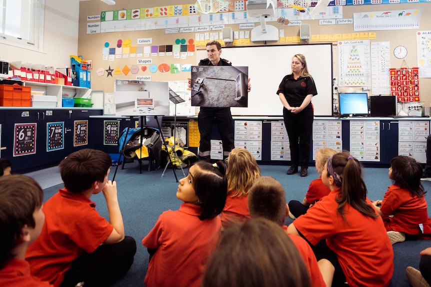 A wide shot of firefighter Michael Hatfield speaking to a group of students in class at Mosman Park School for Deaf Children.