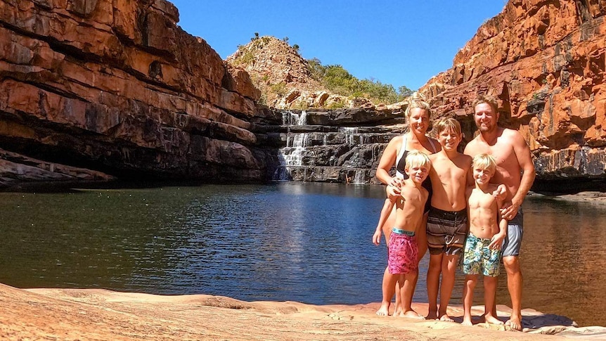 Natasha Skinner and her family stand next to a waterfall in WA.