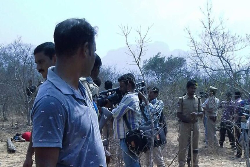 Indian security guards gather at the crime scene in Chittoor where forest workers were killed