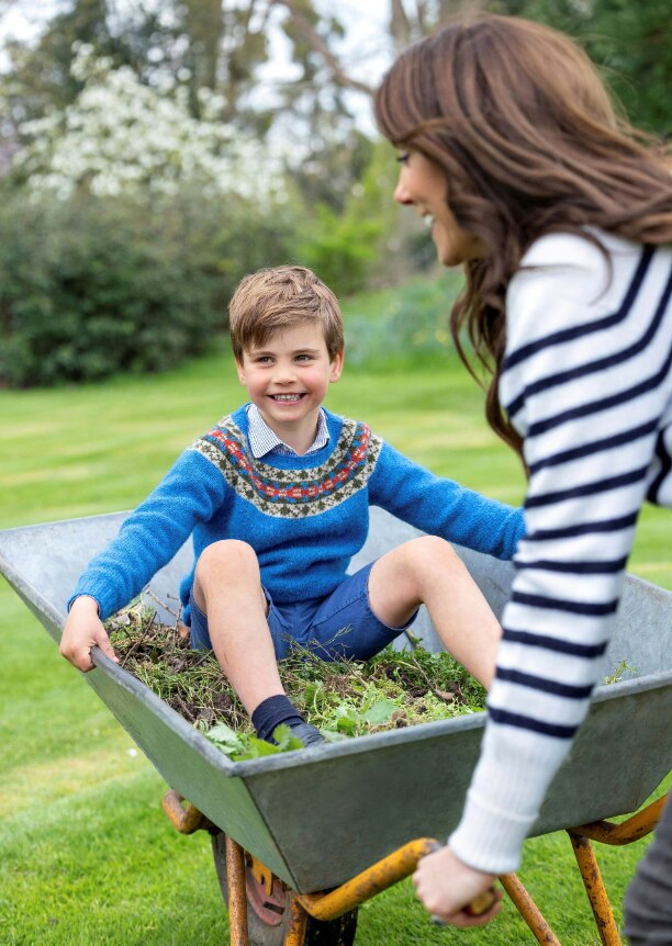 Britain's Prince Louis grinning while sitting in a wheelbarrow