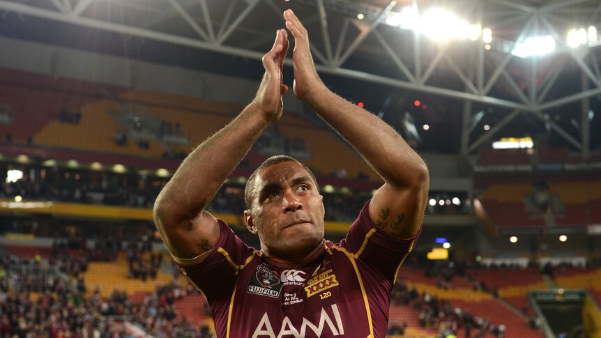 A Queensland State of Origin player claps with his hands above his head following a 2012 match.