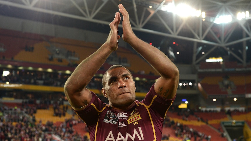 A Queensland State of Origin player claps with his hands above his head following a 2012 match.