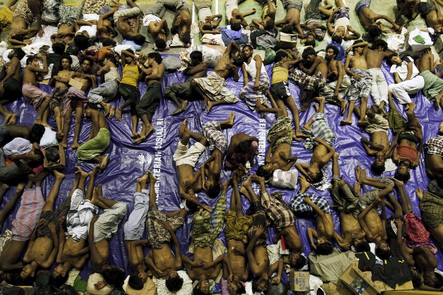 Migrants believed to be Rohingya rest inside a shelter after being resuced off the coast of Indonesia