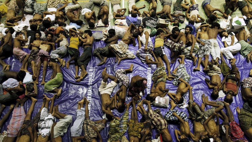 Migrants believed to be Rohingya rest inside a shelter after being resuced off the coast of Indonesia