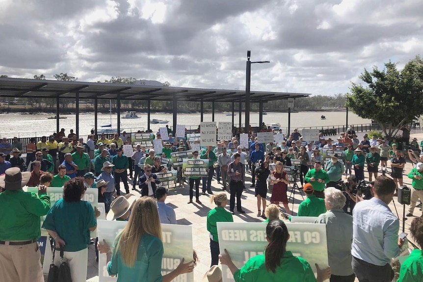 A group of protesters gathered on the bank of a river