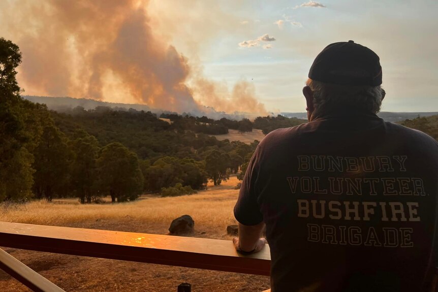A firefighter watches bushfire smoke from a fire.