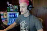 Ninja looks at a computer monitor as he plays Fortnite