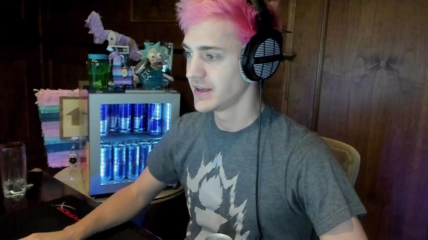 Ninja looks at a computer monitor as he plays Fortnite