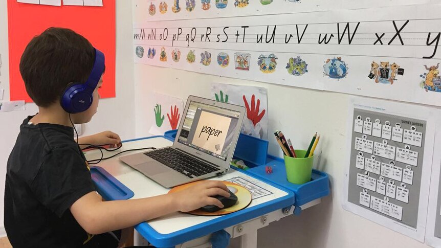 Queensland distance education student Bryce Magerl, 7, sits at a desk on a computer.