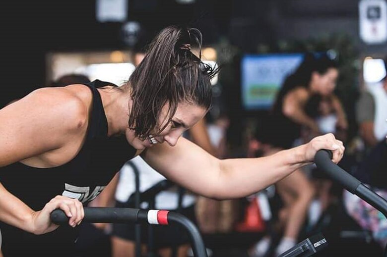 Hannah Clarke on an exercise bike at a CrossFit competition in New Zealand.