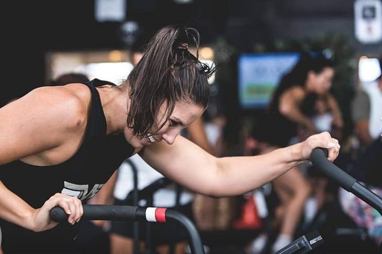 Hannah Clarke on an exercise bike at a CrossFit competition in New Zealand.