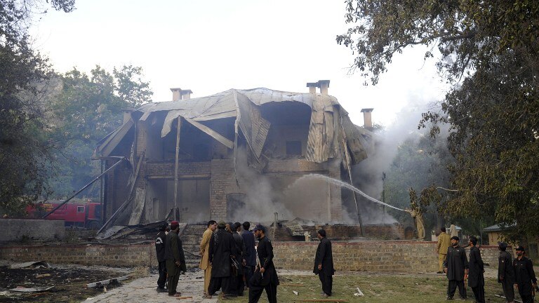 Firemen extinguish a fire at the Ziarat residence in Pakistan after it was bombed by militants