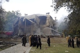 Firemen extinguish a fire at the Ziarat residence in Pakistan after it was bombed by militants