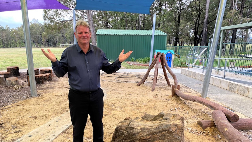 An older man stands in a primary school playground