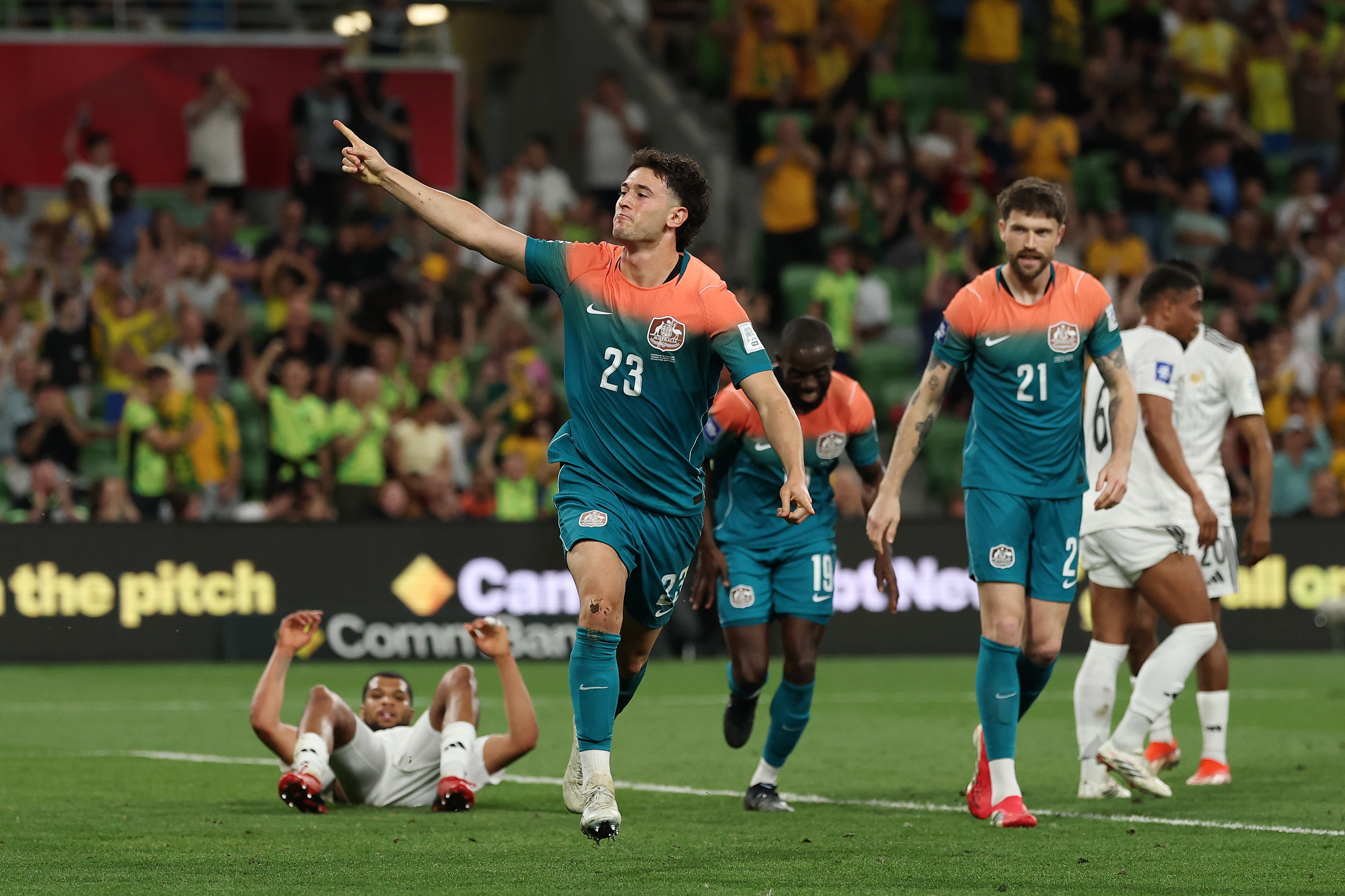 O jogador do Socceroos, Alessandro Circati, tem um dedo apontado para o ar enquanto comemora um gol