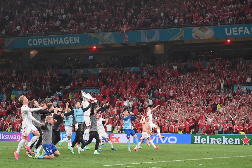Players dance and wave to the crowd after Denmark's crucial win over Russia at Euro 2020.