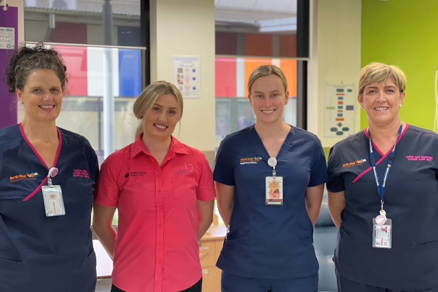 group of nurses smile at camera in hospital