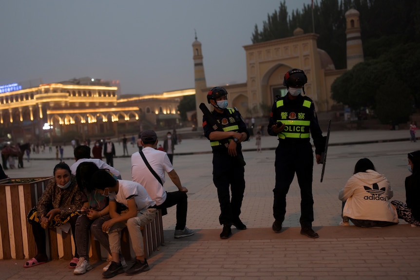 Police officers patrol the square in front of a mosque in Xinjiang