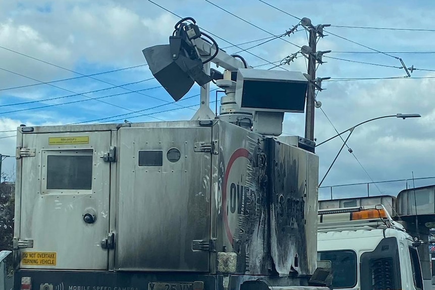 A mobile speed camera blackened by burning.