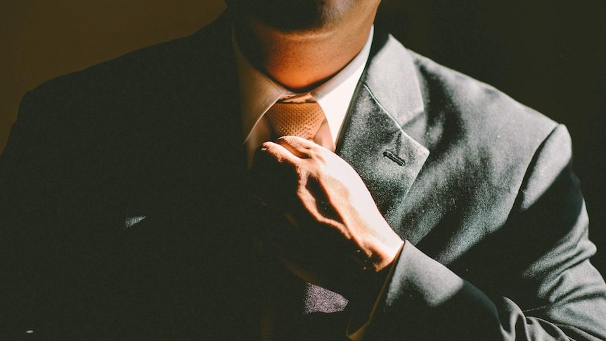 Man adjusts tie on his suit