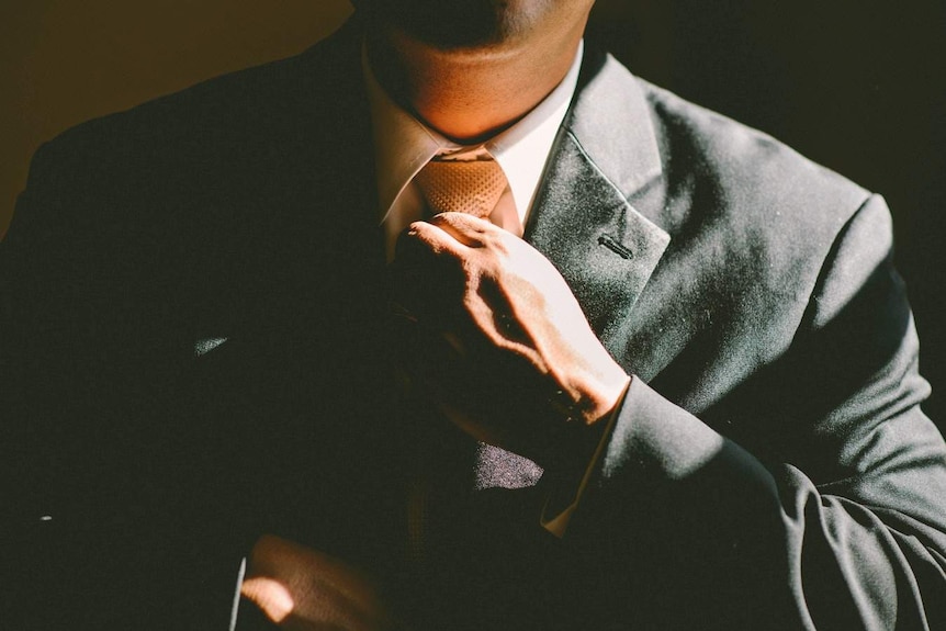 Man adjusts tie on his suit