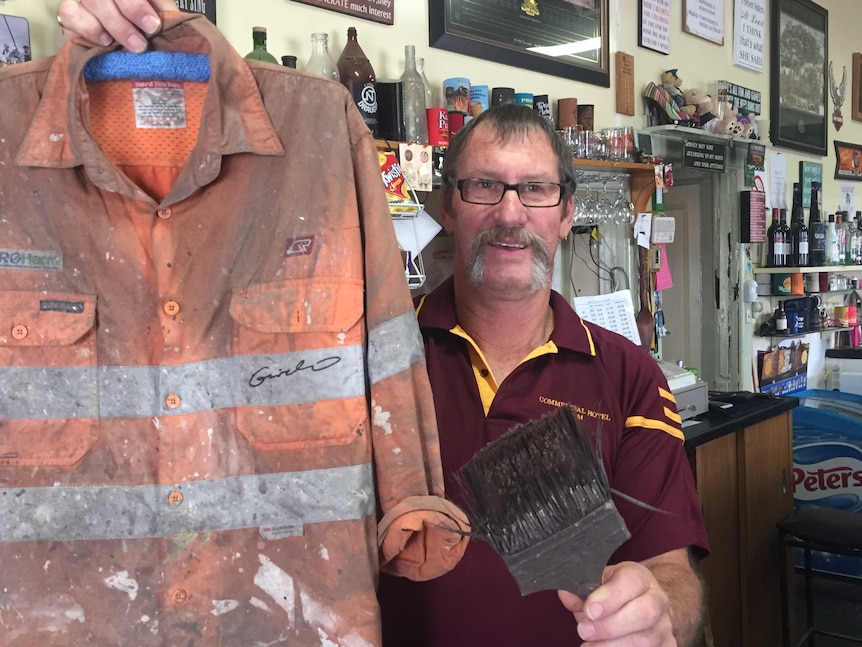 Brim Hotel owner Rodney Holland with Guido van Helten's shirt and paintbrush.