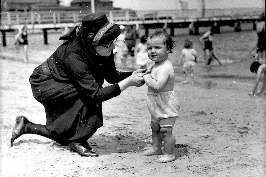 A woman and child on a shoreline.