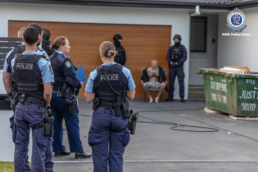 new south wales police officers arrest a man at a house in western sydney