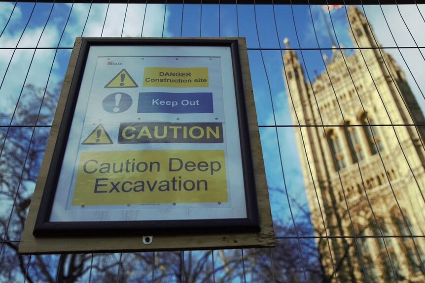 A construction warning sign on a fence outside the Palace of Westminster.