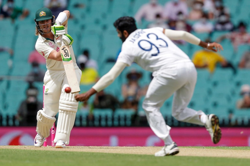 Australia batsman Will Pucovski drives and India bowler Jasprit Bumrah fields during the cricket Test at the SCG.