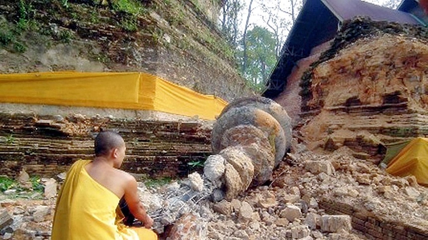 A Thai Buddhist monk inspects a fallen stupa of the Chedi Luang pagoda a day after an earthquake