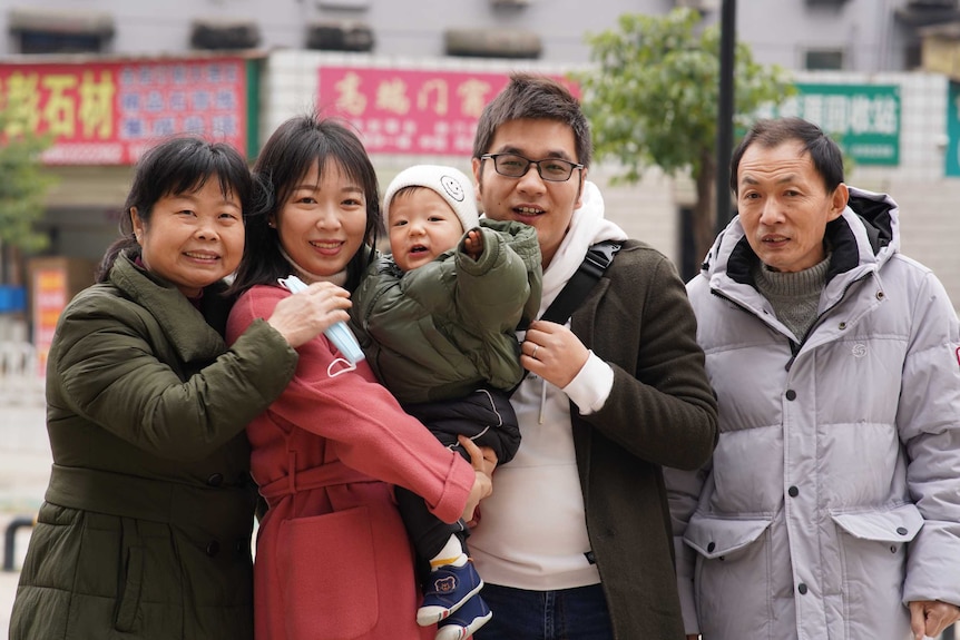 A family of five taking photos and smile happily