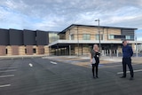 A woman and a man stand outside a newly built hospital