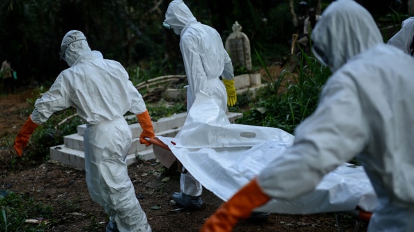 A volunteer medical team carries the body of an Ebola victim.