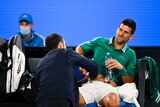 Novak Djokovic of Serbia receives medical attention