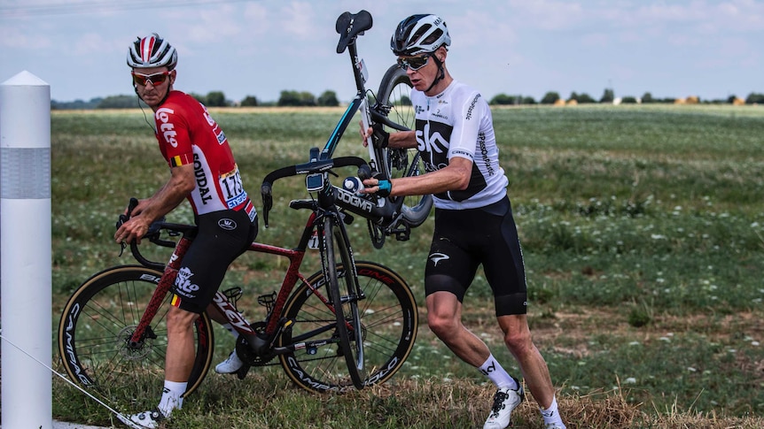 Chris Froome (R), and Jasper De Buyst (L), get back on the road after a crash at the Tour de France.