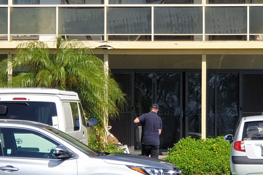 police technician walking into a beachside home