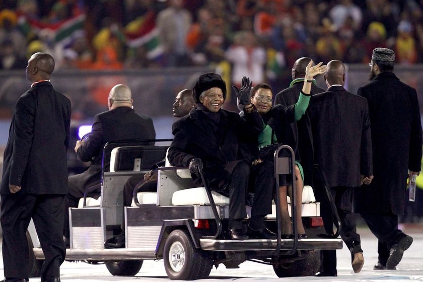 Nelson Mandela and his wife Graca Machel wave to the crowd at Soccer City stadium