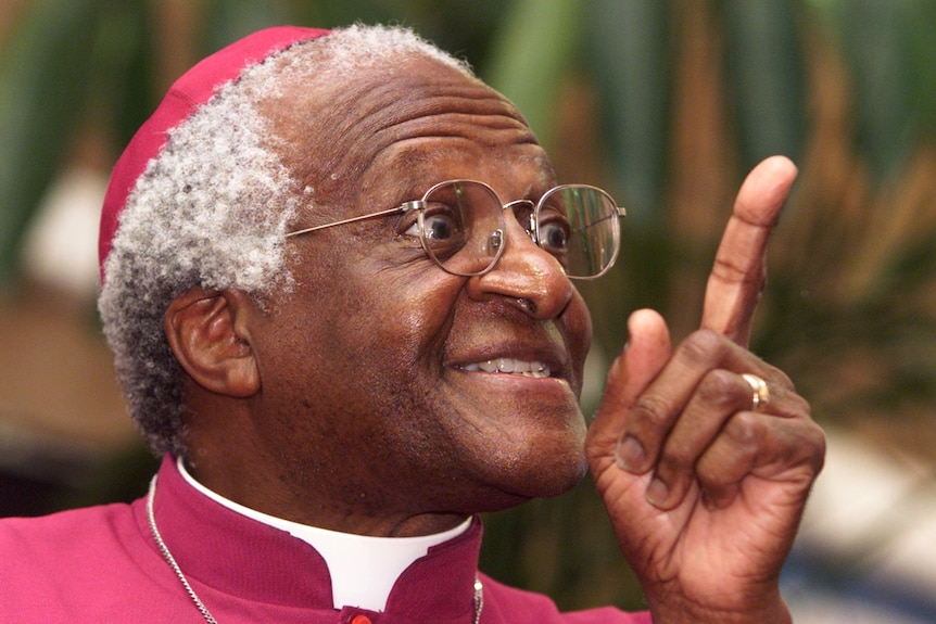 Archbishop Desmond Tutu smiles and points